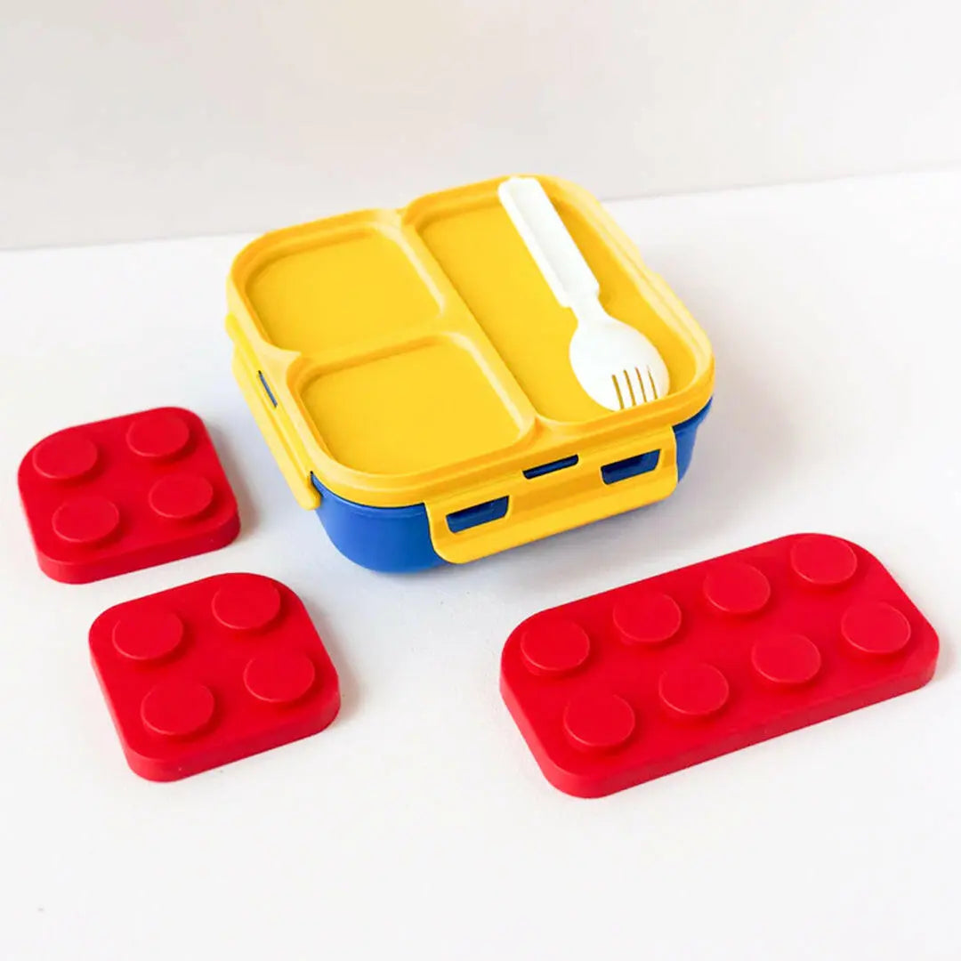 Yellow and blue bento box with red brick-shaped containers on a white background