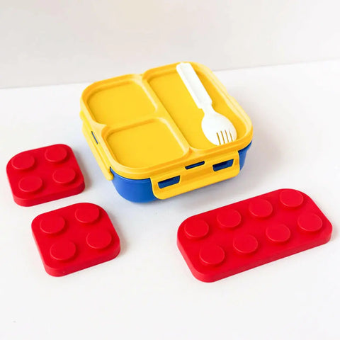 Yellow and blue bento box with red brick-shaped containers on a white background